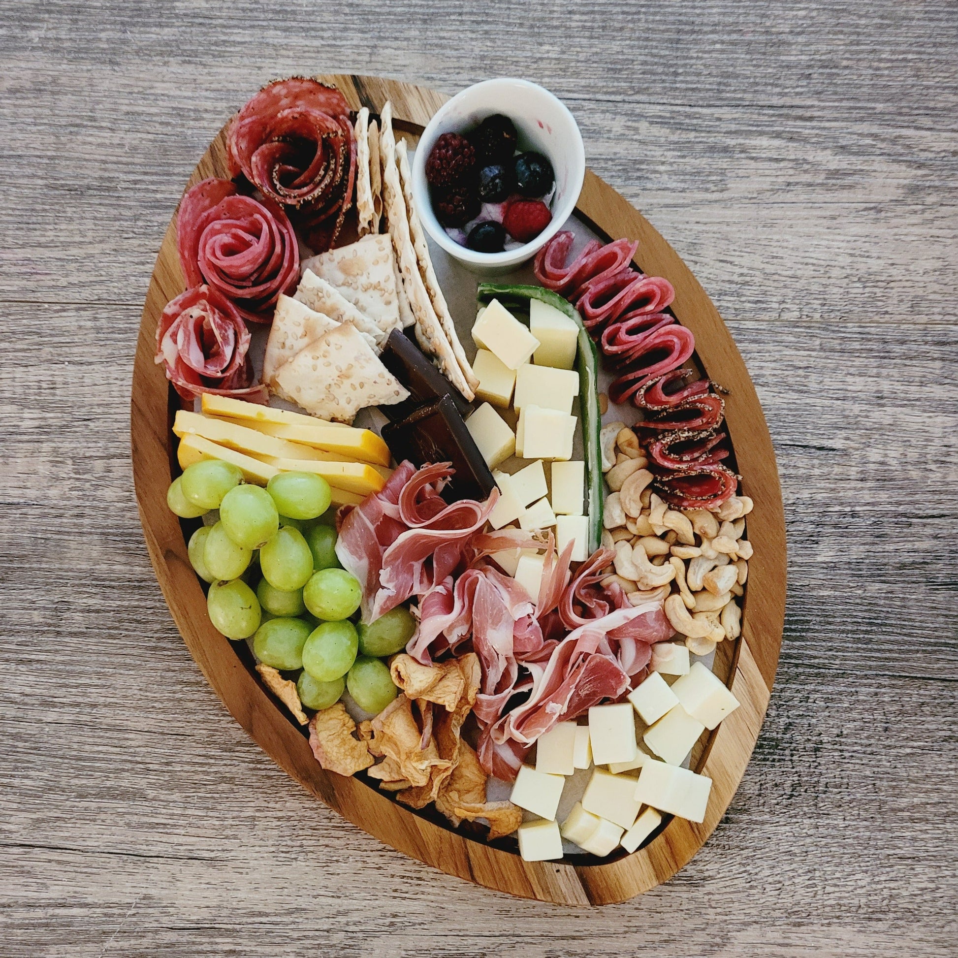 football shaped charcuterie board loaded with meats and cheese selection