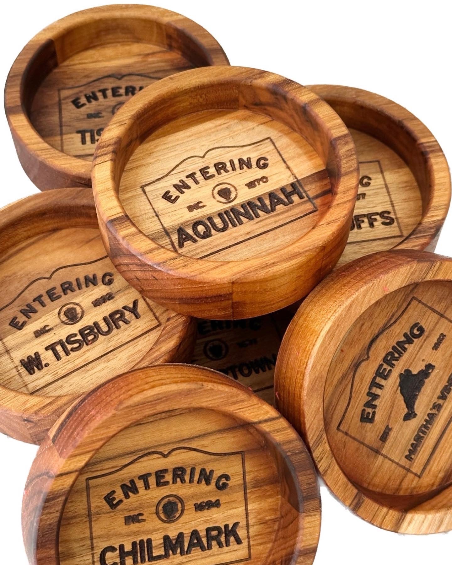 A close-up of a wooden wine coaster showcasing elegant engraving