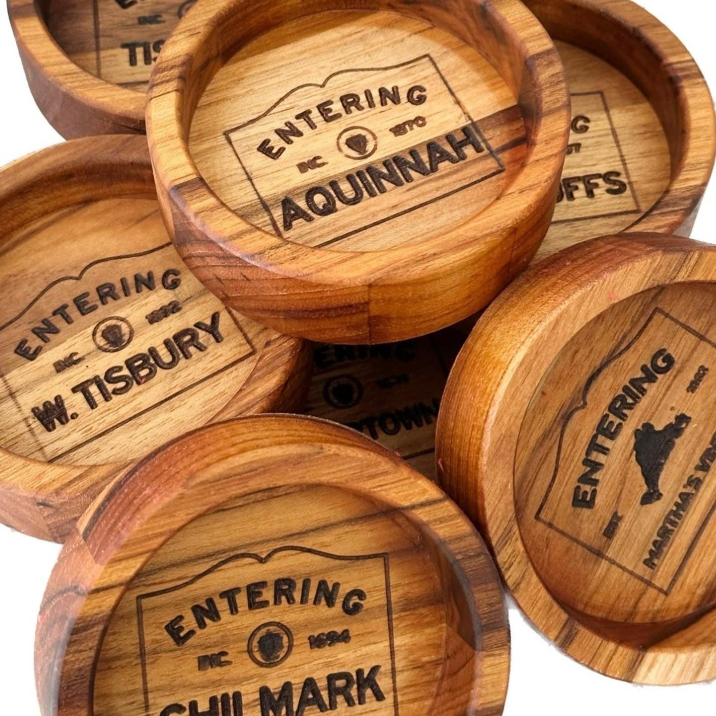 A close-up of a wooden wine coaster showcasing elegant engraving