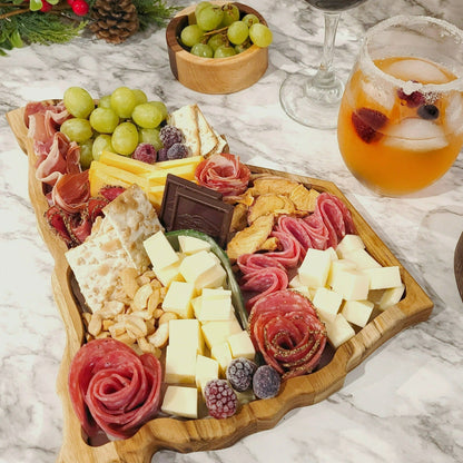 South Carolina shaped wooden charcuterie board boasting a delicious arrangement of artisanal cheeses, meats, grapes, and nuts