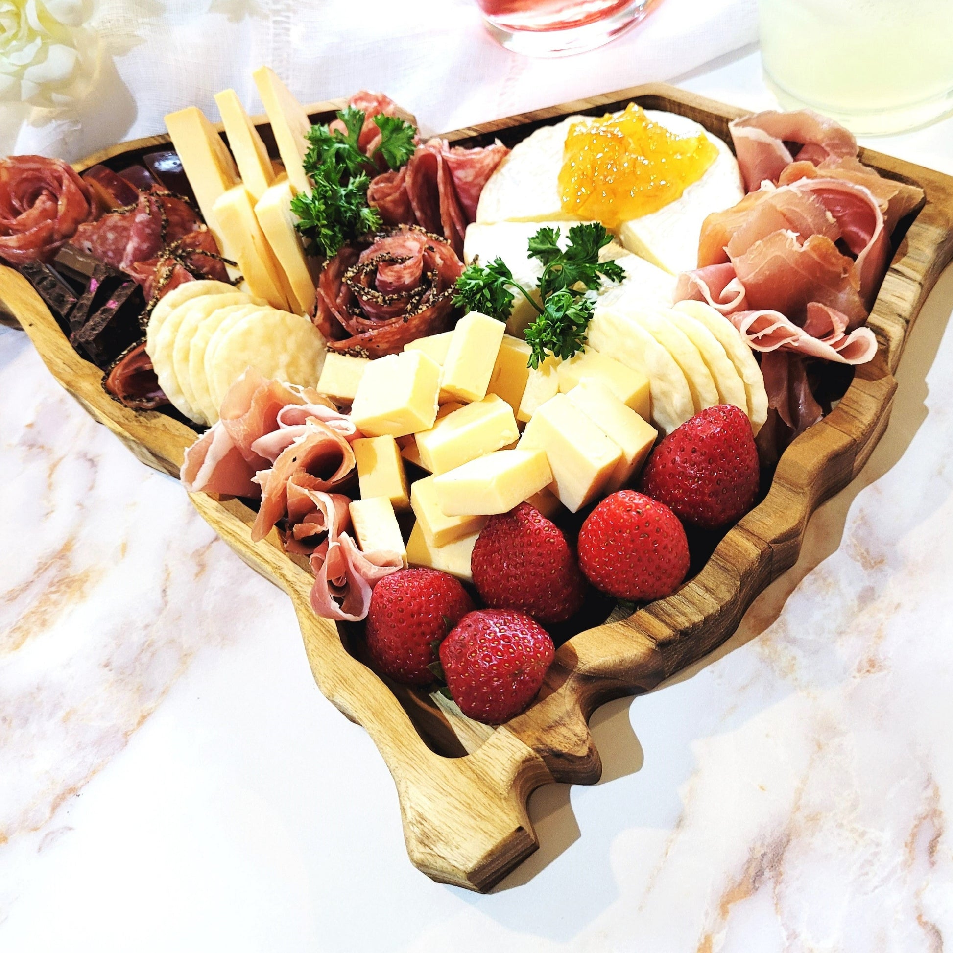 State-shaped wooden charcuterie board showcasing South Carolina with delicious assortment of meats, cheeses, and crackers